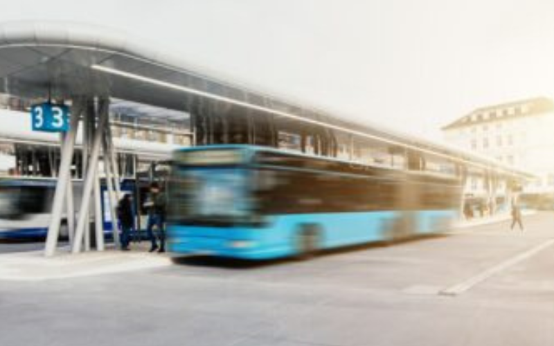 Bus articulé à un arrêt.